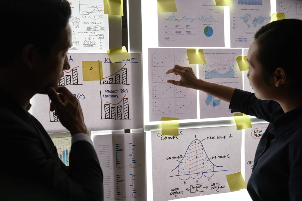 Deux professionnels structurant graphiques et informations pour cartographier une veille scientifique