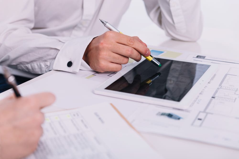 Travail sur tablette et documents techniques pour rédiger un rapport d’étude de faisabilité